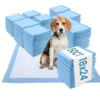 Dog sitting on medium training pad with stacks of blue disposable dog pee pads, 50 count 18x24-inch pack